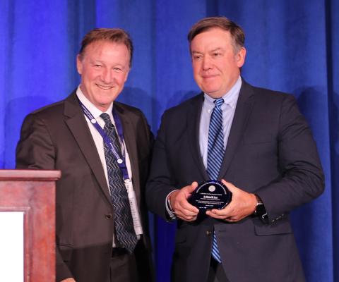 Michael Crow, Arizona State University, receiving the award from James Buizer